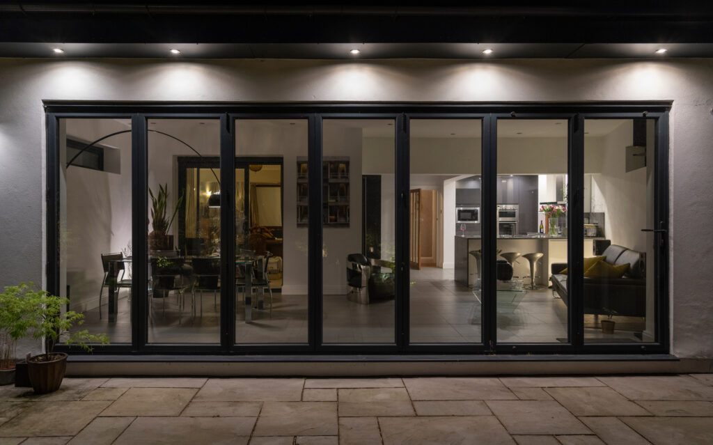 Stylish, bifold doors at night with downlighters revealing inter